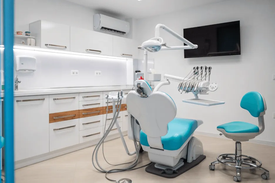 Стоматологичен кабинет, включващ професионално кресло и мивка за пациенти.